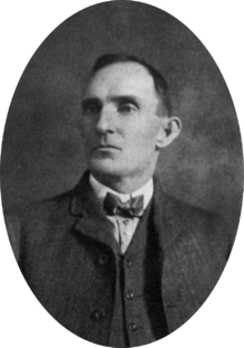Bust portrait of a man in a late nineteenth century, three-piece suit and bow-tie, looking off to his right
