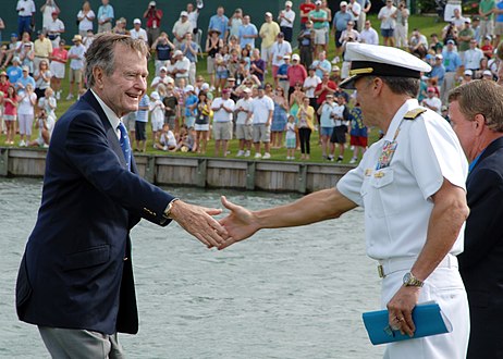 Former President George H. W. Bush shakes hands with Rear Adm. Joseph Kernan and then received the Professional Golfers Association Tour Lifetime Achievement Award in 2009.