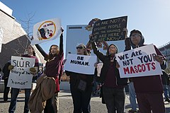photograph of several protesters with signs opposing the use of the name Redskins and the logo of a Native American by the Washington NFL team in Minneapolis, Minnesota, November 2014