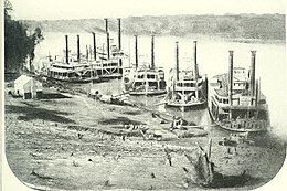 Photo shows six Civil War era steamboats tied up at a riverbank.