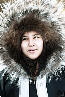 Inuit woman wearing parka with traditional large ruff of irregular fur