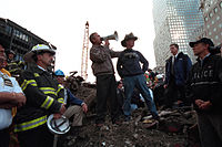 Bush, debout sur les ruines du World Trade Center, fait un discours aux sauveteurs dans un mégaphone.