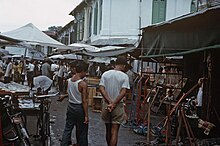 Flea market stalls with people walking between them