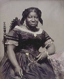 Black-and-white photograph of a Black woman in mid 19th-century dress
