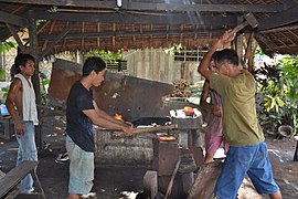 Traditional blacksmiths forging a bolo