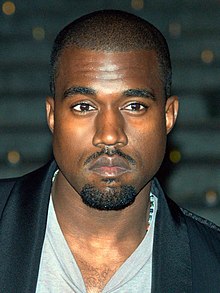 Kanye West in a dark jacket with black sunglasses.