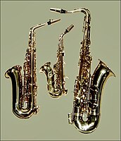 From left to right, an E♭ alto saxophone, a curved B♭ soprano saxophone, and a B♭ tenor saxophone