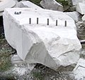 Using plug and feathers to split a block of marble from the quarry