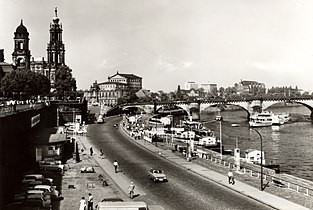 Černobílá fotografie s pohledem na vertikálně ubíhající silnici na břehu Labe, vpravo je katedrála a zámek