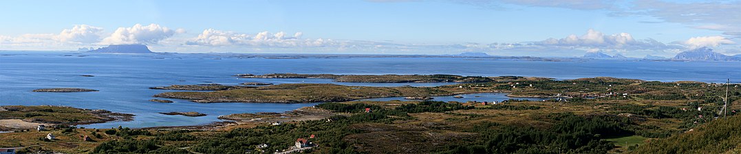 View of the strandflat at Helgeland from the mountain Dønnesfjellet in Dønna. A number of rauks can be seen, from left: Træna, Lovunda, Selvær, Nesøya, Hestmona, Rødøyløva and Lurøyfjellet, all landmarks on the Norwegian Coast.