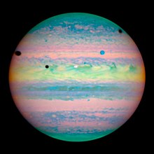 Sur l'hémisphère nord de Jupiter se détachent un disque blanc et un bleuté et trois taches sombres (les ombres portées)