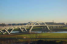 Barevná fotografie s pohledem na moderní obloukový most přes Labe