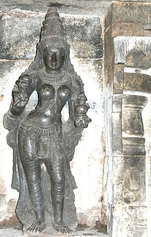 A stone carving of a standing woman with a pot in her left hand and lotus in right