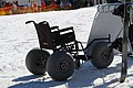 A wheelchair with adaptive tires for travelling across snow at a ski hill. Such chairs can be loaned or rented to users.