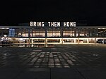 מיצב תאורה ענק עם כיתוב Bring Them Home, שנעשה על ידי האמן נדב ברנע. היכל התרבות, תל אביב
