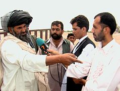 A reporter interviews a man in Helmand Province, Afghanistan, 2009.
