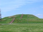 A large earthen mound with steps leading to the top
