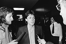 Paul McCartney bliver interviewet af to journalister, der holder mikrofoner.
