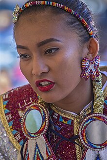 A Chumash woman wearing brightly colored traditional attire
