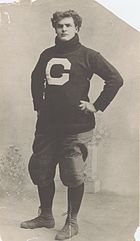 Large young man in a turtleneck and football pants, with hands on hips