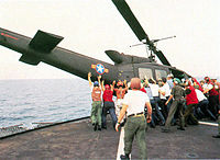 RVNAF Huey is pushed overboard from USS Midway.