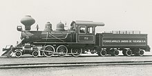 A black-and-white image of an old steam locomotive and tender