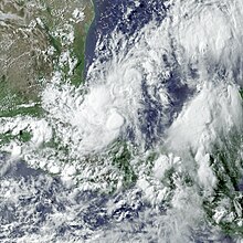 A satellite image of a tropical cyclone featuring thunderstorms scattered over a broad area in a general counterclockwise spiral shape