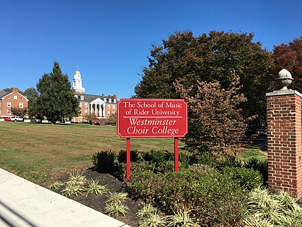 Entrance sign for the college as seen in 2019, which speaks to its relationship with its parent