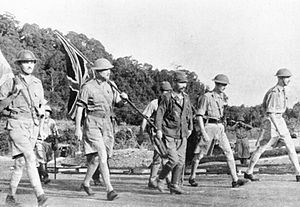 Five British officers and a Japanese officer walk, see caption