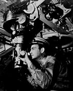 Officer at periscope in control room of a U.S. Navy submarine in World War II