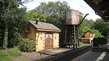 A water tower and two storage buildings adjacent to railroad track