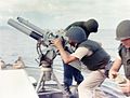 A gun crew on board USCGC Point Comfort (WPB-82317) firing an 81mm mortar during the bombardment of a suspected Viet Cong staging area one mile behind An Thoi in August 1965