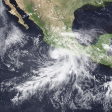 A satellite image of a hurricane near the western coast of Mexico; the cloud pattern resembles a spiral near the center, with an elongated hook curving outwards
