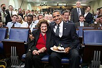 Obama a passé son bras autour des épaules de Thomas, et il tient une assiette pleines de cupcakes décorés par une bougie. Tous deux sont hilares.