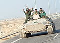Iraqi soldiers atop an MT-LB armoured personell carrier along highway in Iraq, 28 February, 2003.