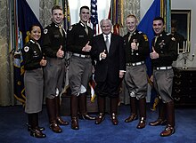 Secretary of Defense Robert Gates standing with 5 other people in uniform; all are giving a thumbs up gesture