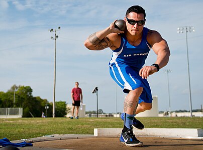 A shot putter performs an isometric press by applying downward pressure onto his bent right leg. This will allow him to turn and spring forwards more powerfully, and channel the muscular force generated by the press into the throw.