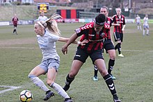 Kelly (left) pushes off a Lewes FC defender, 2018