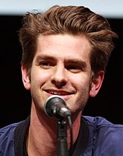 A close-up of Andrew Garfield, with a microphone in front of him.