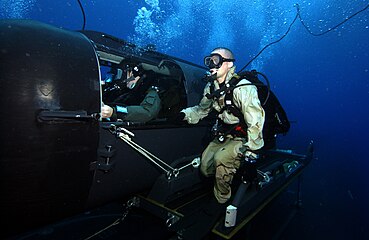 A Navy diver and special operator from SEAL Delivery Team (SDV) 2 perform SDV operations with the nuclear-powered guided-missile submarine USS Florida