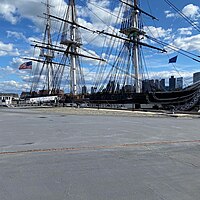 USS Constitution docked in April 2022 with the Boston skyline in the background
