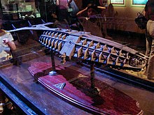 A large model of a mechanical submarine perched atop a flat table mount.
