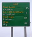 A Scottish sign using the typeface on the Isle of Skye, with place names given in both Scots Gaelic and English, and distances shown in miles.