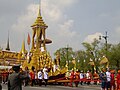 The officers on the Chariot of Great Victory wear the Nobleman's Gowns (ครุยขุนนาง; Khrui Khun Nang) together with the ancient official headgear called Lomphok (ลอมพอก). The Chariot is carrying the urn of Princess Bejaratana Rajasuda to the crematorium at Sanam Luang on 9 April 2012.