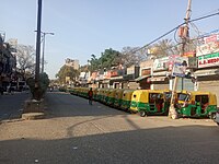 Auto rickshaw stranded in front of closed shops in Delhi