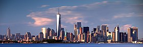 Manhattan aveuc ch' One World Trade Center, aveuc l' éstatue del Libertè dins l' baie d' New York.
