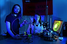 Dos científicos hacen un experimento de luz en un laboratorio de fotónica biomédica