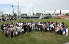 People are seen standing in a field at the Kennedy Space Center during a naturalization ceremony.