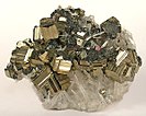 Pyrite from the Sweet Home Mine, with golden striated cubes intergrown with minor tetrahedrite, on a bed of transparent quartz needles