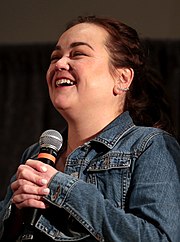 A smiling Trina Nishimura with a microphone at a 2018 Arizona comic fest